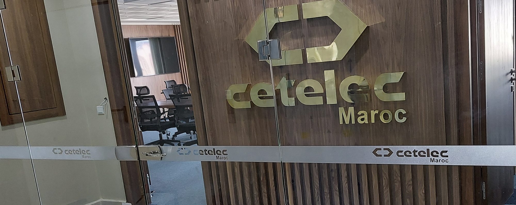 接待墙前带有 Cetelec 磨砂腰线的无框玻璃隔断