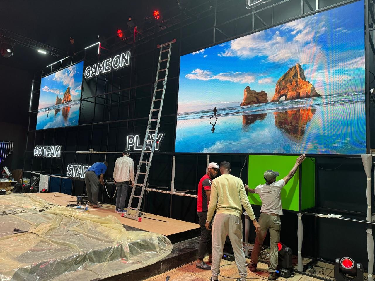 Installers fitting the LED screens and light boxes on the stage grid