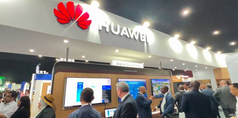 Visitors under the illuminated Huawei header at the Digital Governance display