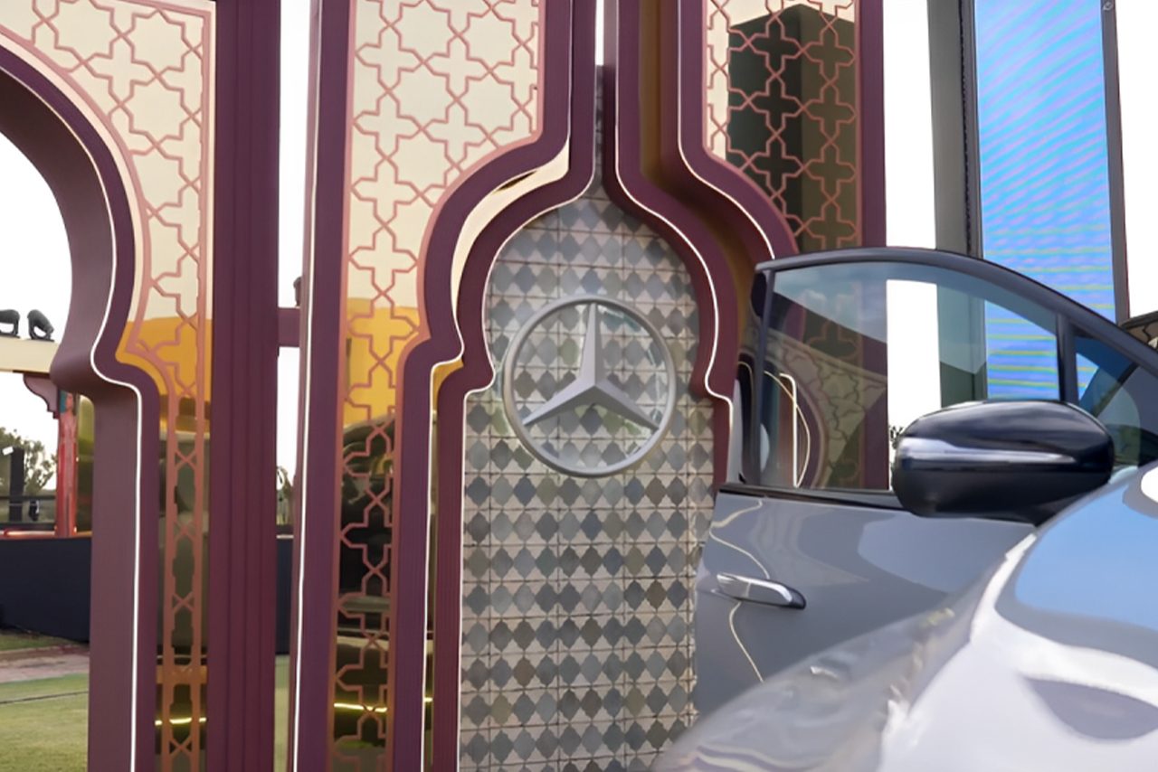 Close-up of the Mercedes-Benz star on the patterned arch beside the EQS SUV