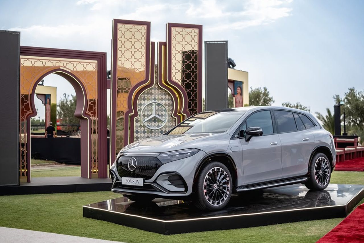 Mercedes-Benz EQS SUV on a black platform between Moroccan-patterned arches in daylight