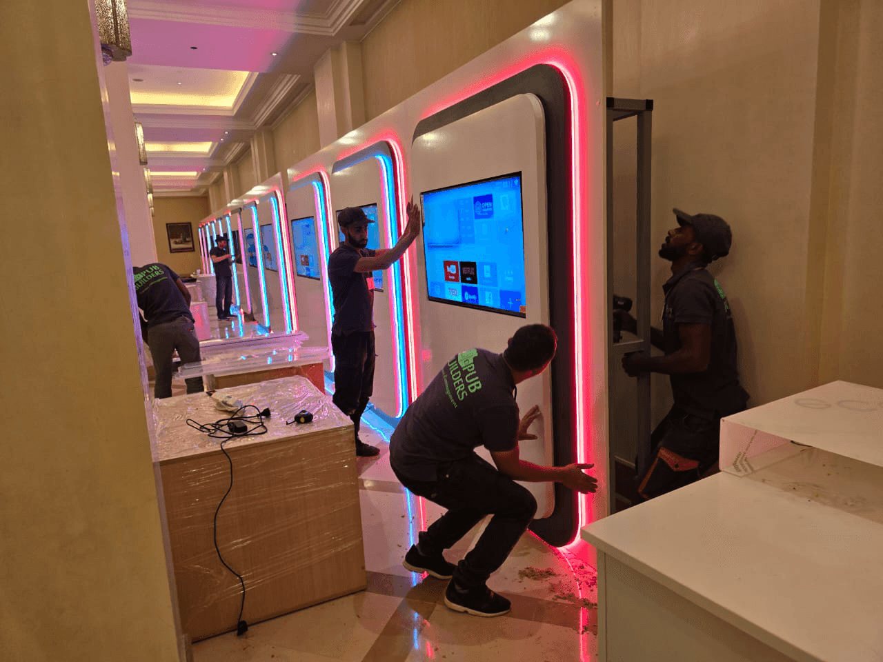 Installers fitting illuminated display units on site
